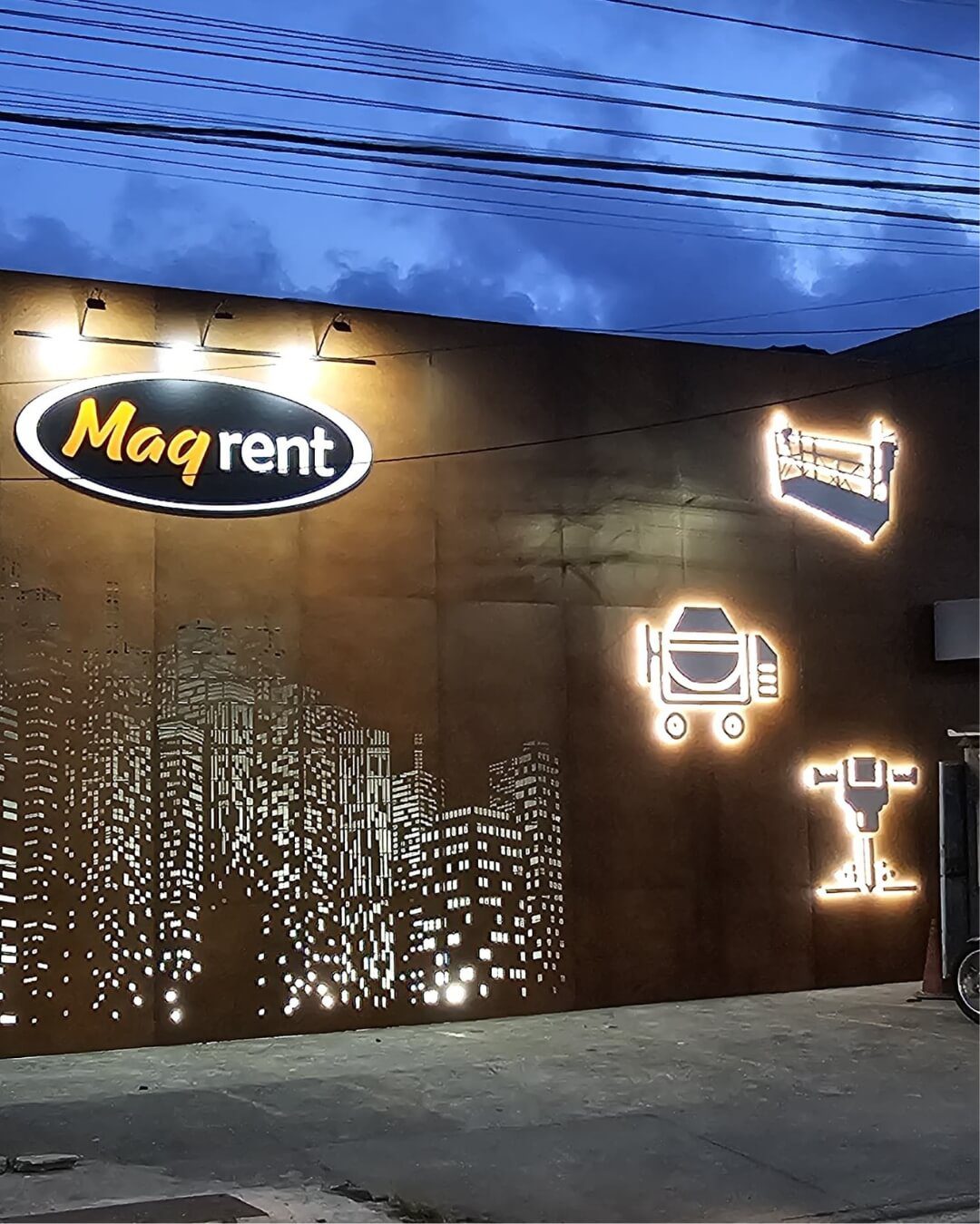 Fachada industrial com recorte de cidade e ícones iluminados