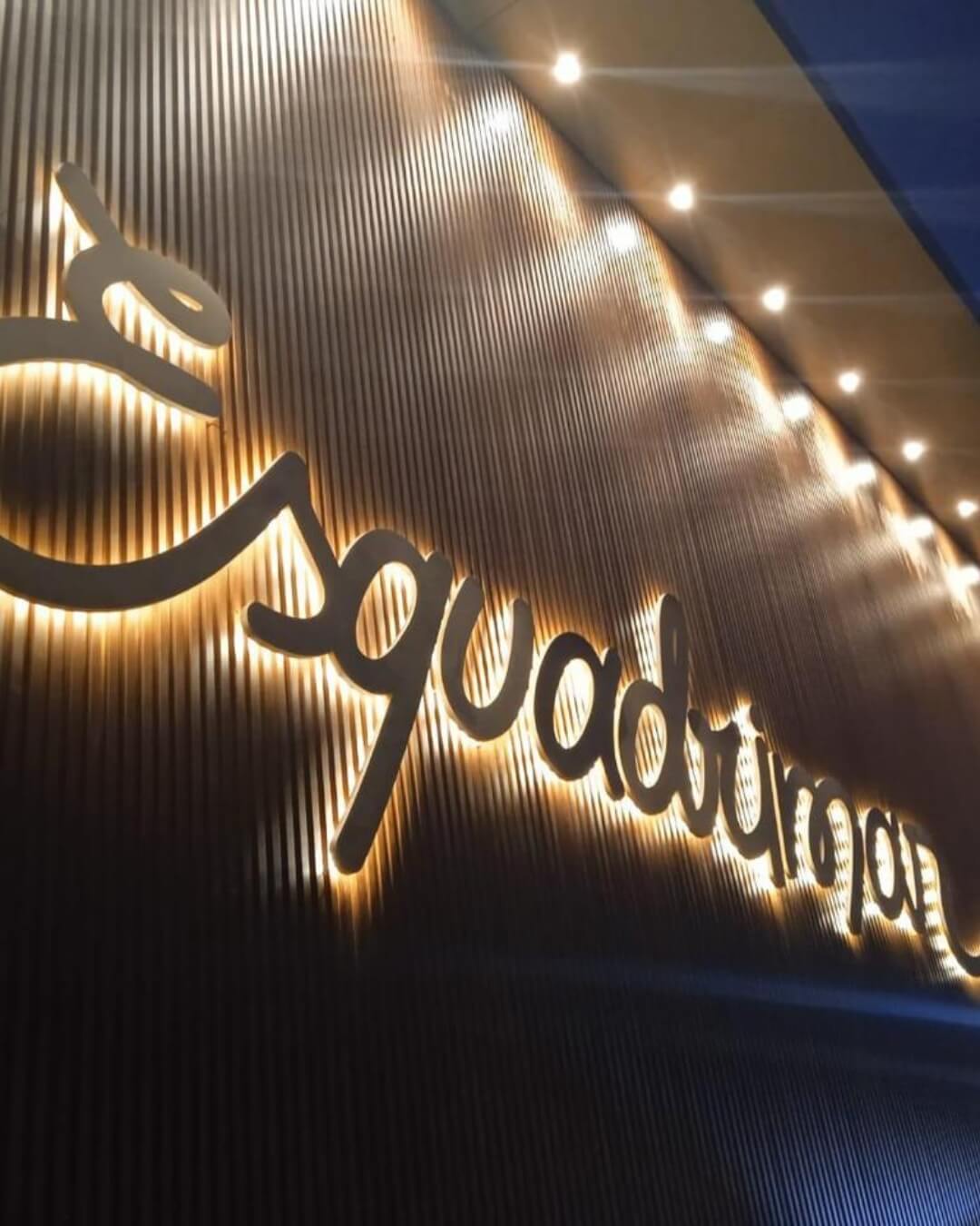 Detalhe de revestimento ripado e letras iluminadas